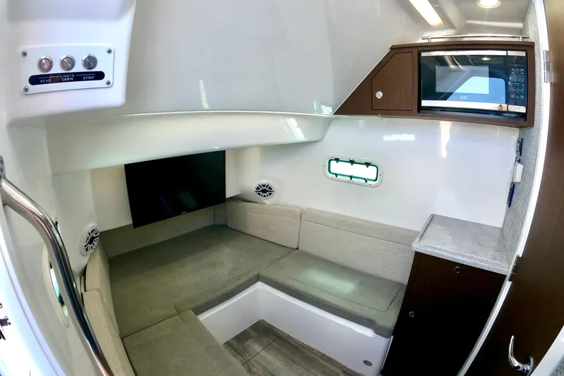 Slide: The Image of 2023 Everglades 395 Center Console cabin interior with seating, TV, and microwave. - 49