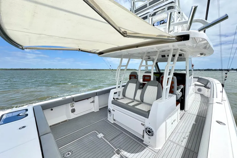 Slide: The Image of 2023 Everglades 395 Center Console boat with spacious seating and canopy on open water. - 9