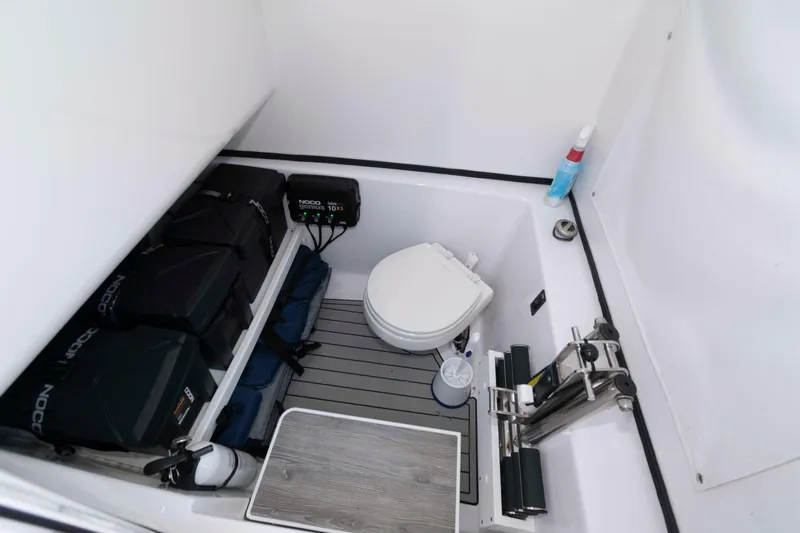 Slide: The Image of 2022 Sportsman Open 282 Center Console boat interior with storage and marine toilet. - 16