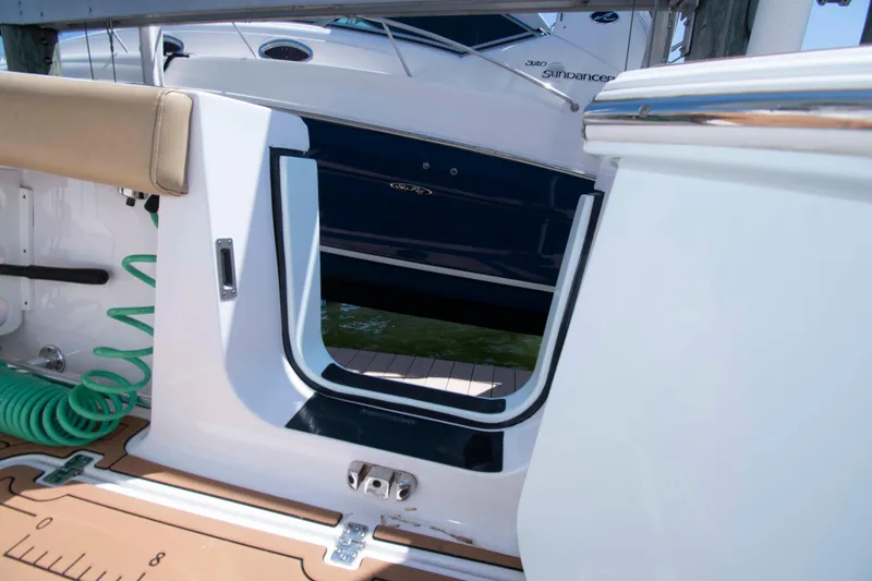 Slide: The Image of 2022 Sportsman Open 282 Center Console boat with open side door and green hose. - 17