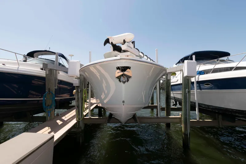Slide: The Image of 2022 Sportsman Open 282 Center Console boat docked between two others. - 2