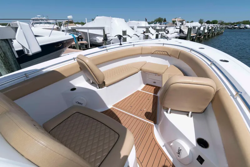Slide: The Image of 2022 Sportsman Open 282 Center Console boat with tan seating, docked at marina. - 4
