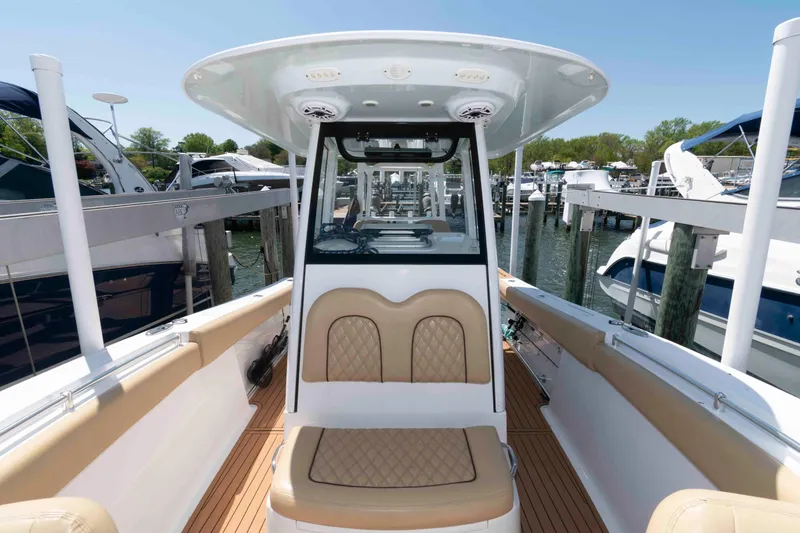 Slide: The Image of 2022 Sportsman Open 282 Center Console boat docked at marina, featuring tan seating and sleek design. - 5
