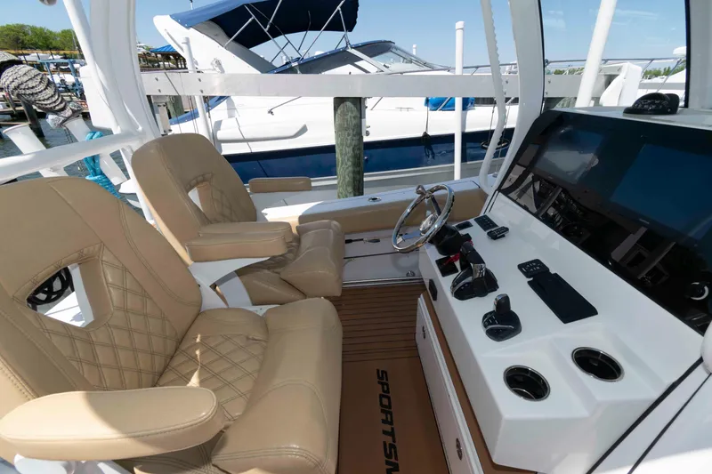 Slide: The Image of 2022 Sportsman Open 282 Center Console boat interior with beige seating and modern controls. - 7