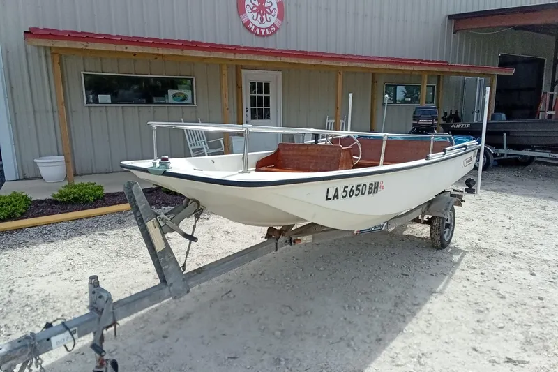 Slide: The Image of 1985 Boston Whaler 13 Sport boat on trailer outside a building. - 3