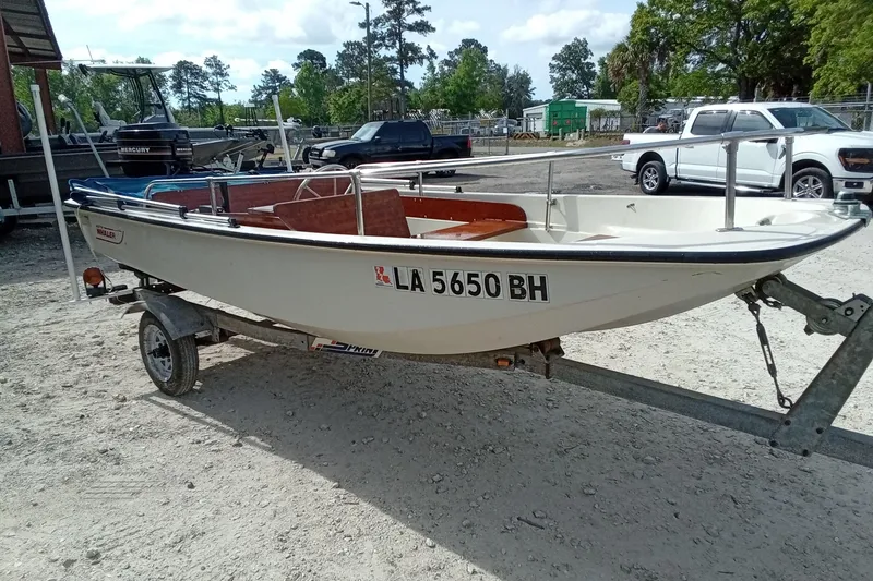 Slide: The Image of 1985 Boston Whaler 13 Sport boat on trailer in outdoor setting. - 5
