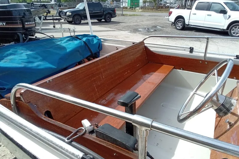 Slide: The Image of 1985 Boston Whaler 13 Sport boat interior with wooden seating and steering wheel. - 6
