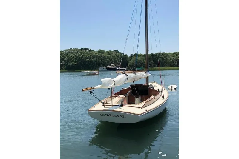 Slide: The Image of 2020 Wianno Senior sailboat named "Hurricane" docked on calm water. - 3