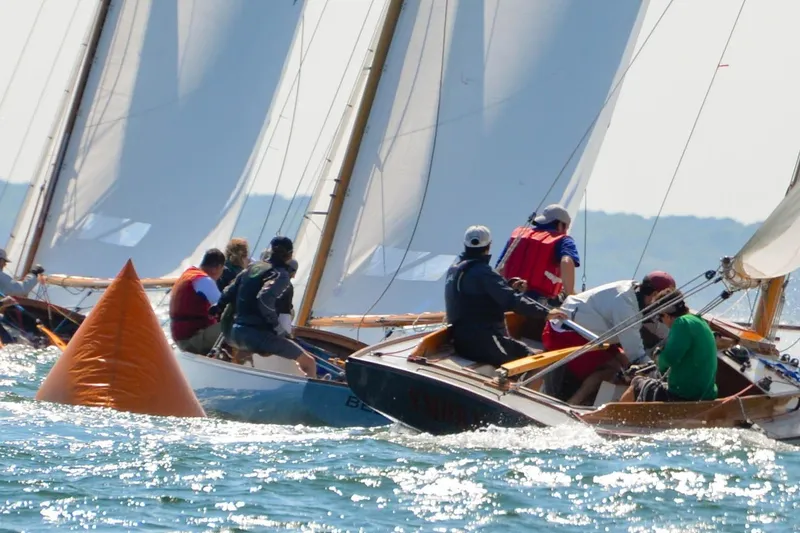 Slide: The Image of Sailboats racing near an orange buoy, featuring 2020 Wianno Senior models. - 7