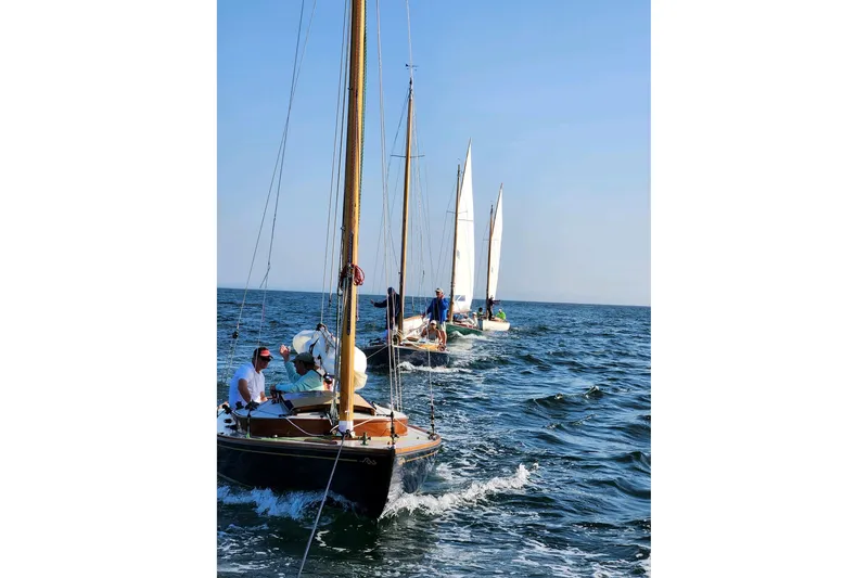 Slide: The Image of Sailboats on the ocean, featuring a 2020 Wianno Senior model, under clear blue skies. - 8