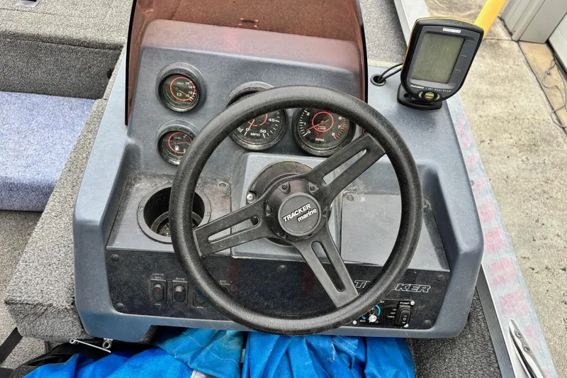 Slide: The Image of 1991 Bass Tracker Tournament TX-17 boat dashboard with steering wheel and gauges. - 6