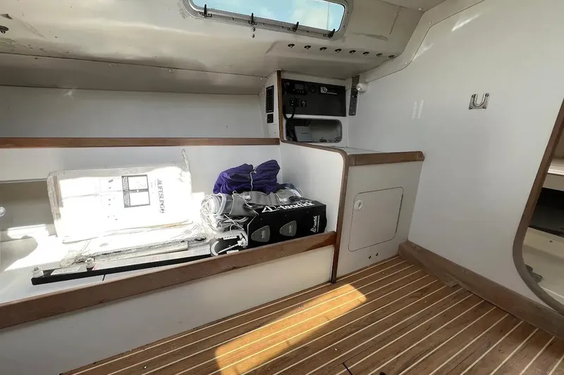 Slide: The Image of Interior of a 2001 J Boats J/105 sailboat with wooden flooring and storage compartments. - 12