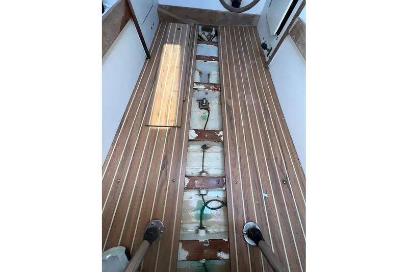 Slide: The Image of Interior view of a 2001 J Boats J/105 sailboat, showcasing wooden flooring and exposed compartments. - 14