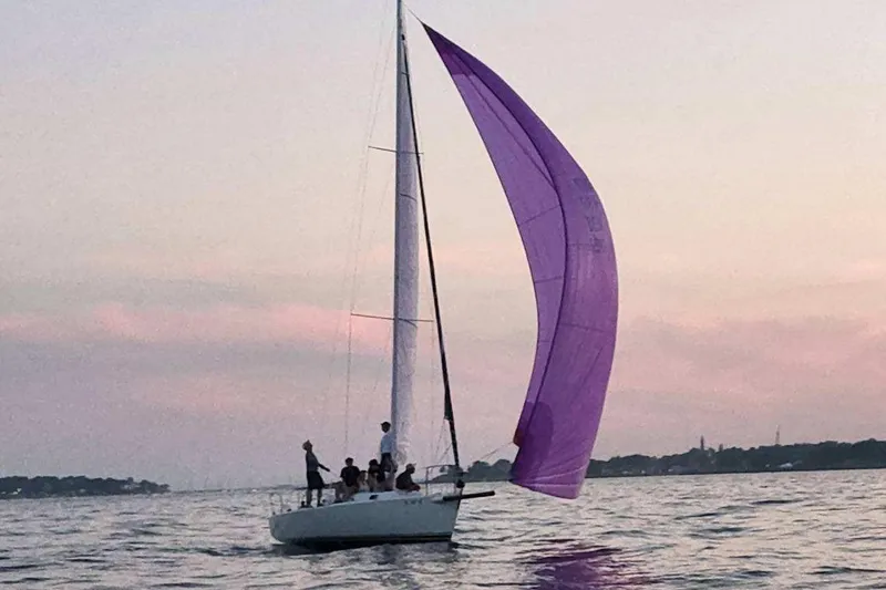 Slide: The Image of Sailboat J/105 from 2001 with purple spinnaker at sunset on calm waters. - 4