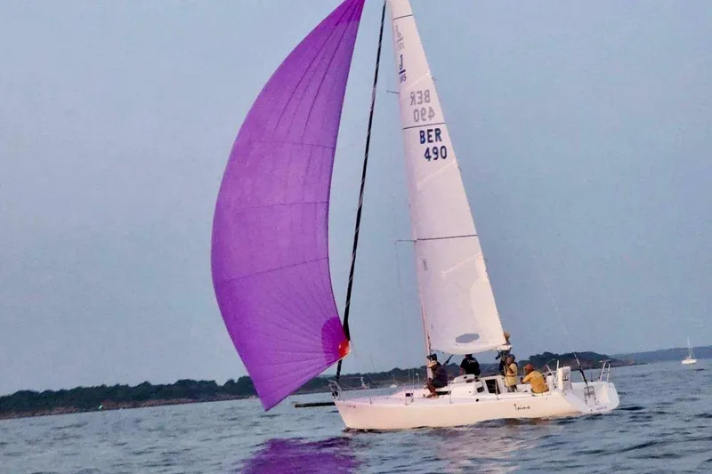 Slide: The Image of 2001 J Boats J/105 sailing with a vibrant purple spinnaker on calm waters. - 5