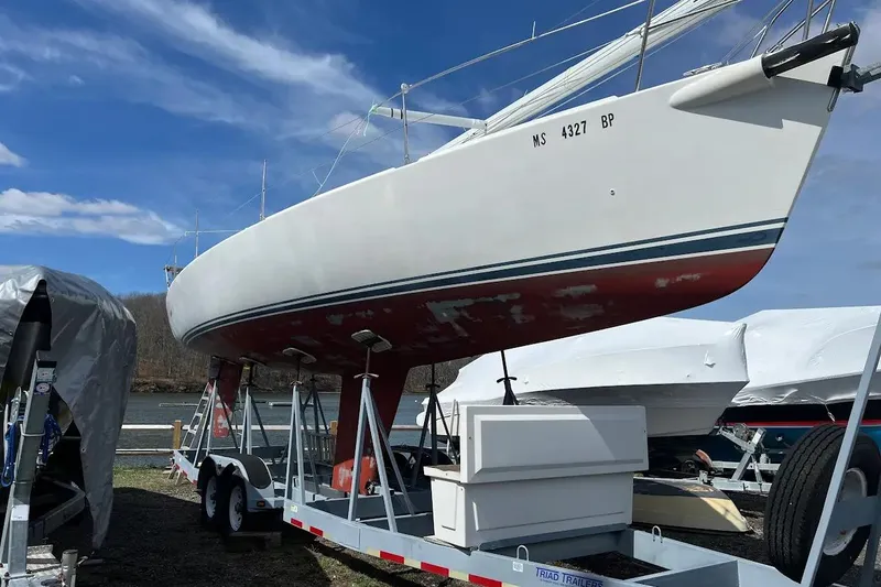 Slide: The Image of 2001 J Boats J/105 sailboat on trailer, ready for transport under clear blue sky. - 6