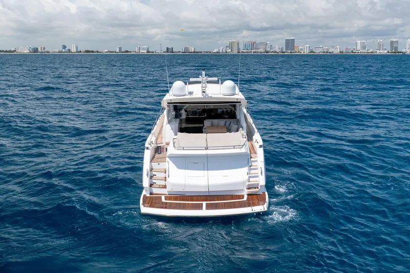 Slide: The Image of 2020 Sunseeker Predator 74 XPS yacht cruising on open water with city skyline backdrop. - 107