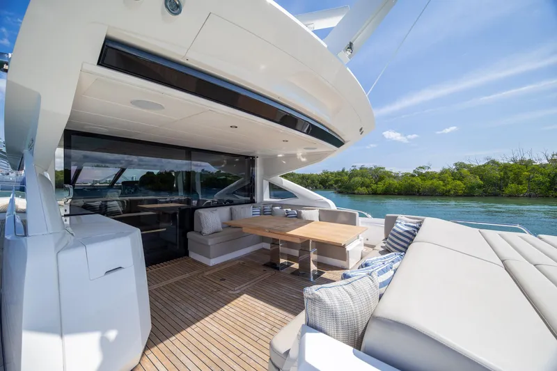 Slide: The Image of Luxurious Sunseeker Predator 74 XPS yacht deck with seating, table, and scenic water view. - 3