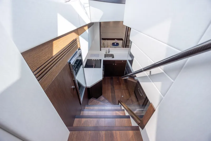 Slide: The Image of Luxurious interior of 2020 Sunseeker Predator 74 XPS yacht, featuring sleek wooden stairs and modern kitchen. - 30