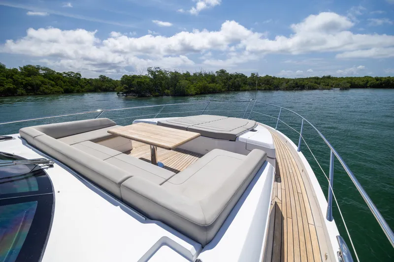 Slide: The Image of Luxurious Sunseeker Predator 74 XPS yacht deck with seating, cruising on serene waters. - 4