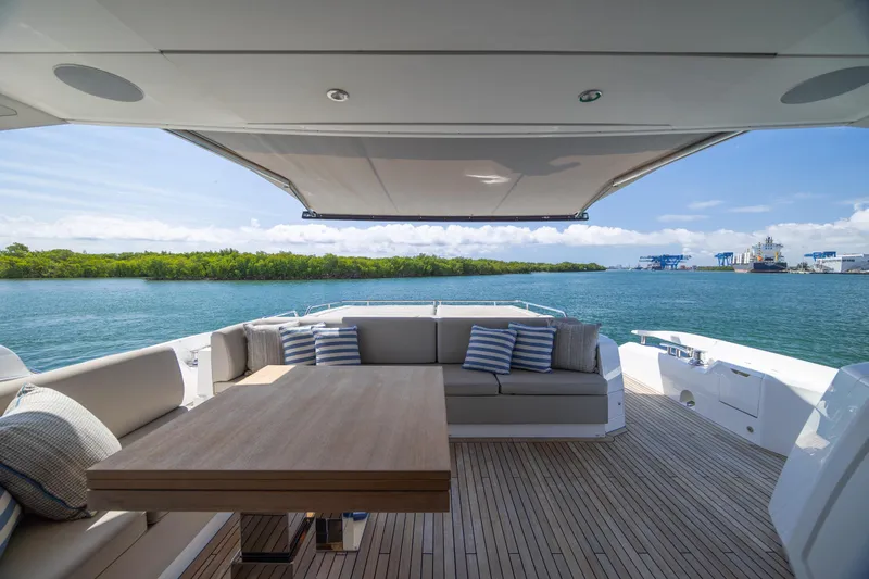 Slide: The Image of Luxurious Sunseeker Predator 74 XPS yacht deck with seating, table, and scenic ocean view. - 75