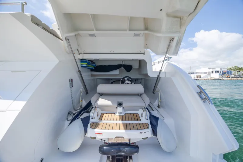 Slide: The Image of Sunseeker Predator 74 XPS 2020 yacht with open garage and tender, docked by the sea. - 98