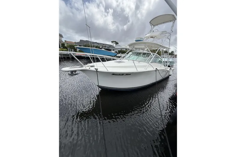 The Image of 2005 Albemarle 30 Express boat docked on a calm waterway under cloudy skies. - 0