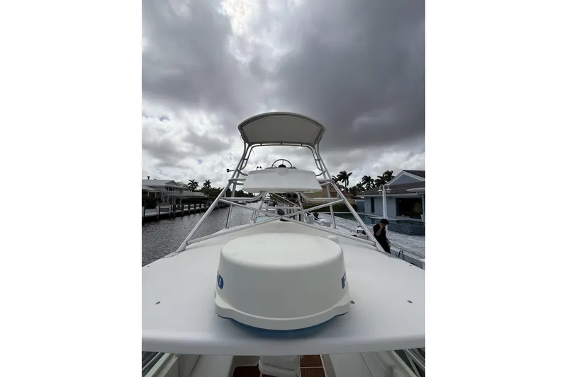 Slide: The Image of 2005 Albemarle 30 Express boat under cloudy skies, docked near waterfront homes. - 11