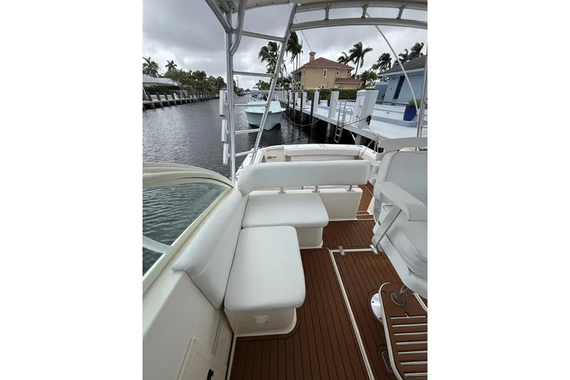 Slide: The Image of 2005 Albemarle 30 Express boat with white seating and wooden deck, docked by waterfront homes. - 18