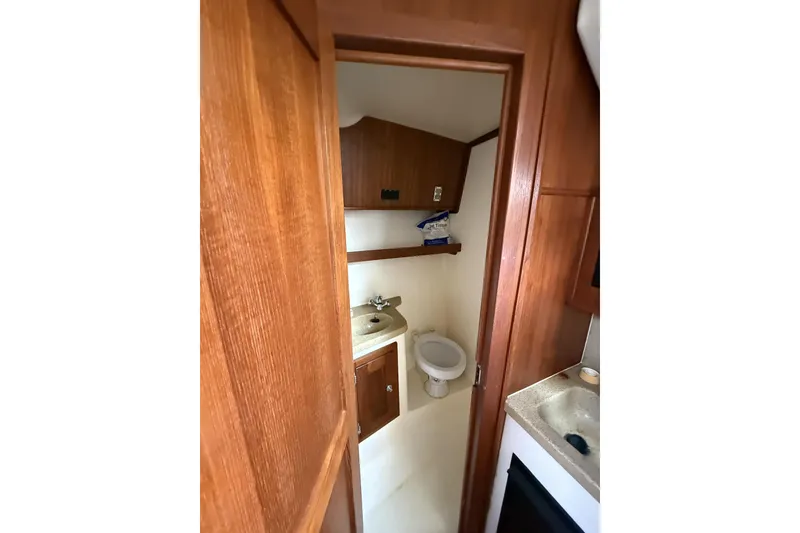 Slide: The Image of 2005 Albemarle 30 Express boat bathroom with wooden cabinetry and compact sink. - 25
