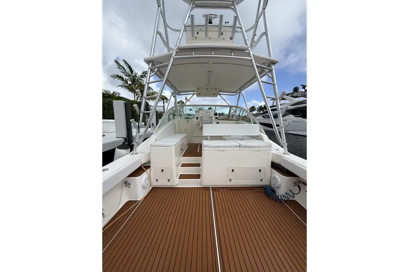 Slide: The Image of 2005 Albemarle 30 Express boat with teak deck and tower, docked near palm trees. - 26