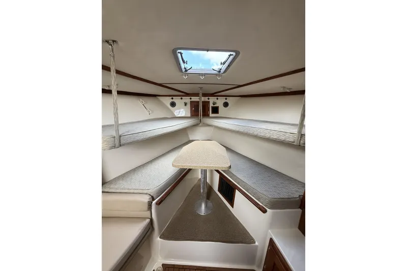 Slide: The Image of 2005 Albemarle 30 Express cabin interior with seating and table, featuring a skylight. - 28