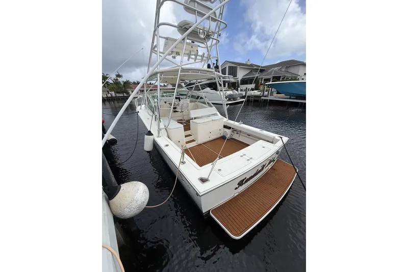 Slide: The Image of 2005 Albemarle 30 Express boat docked, featuring spacious deck and fishing tower. - 5