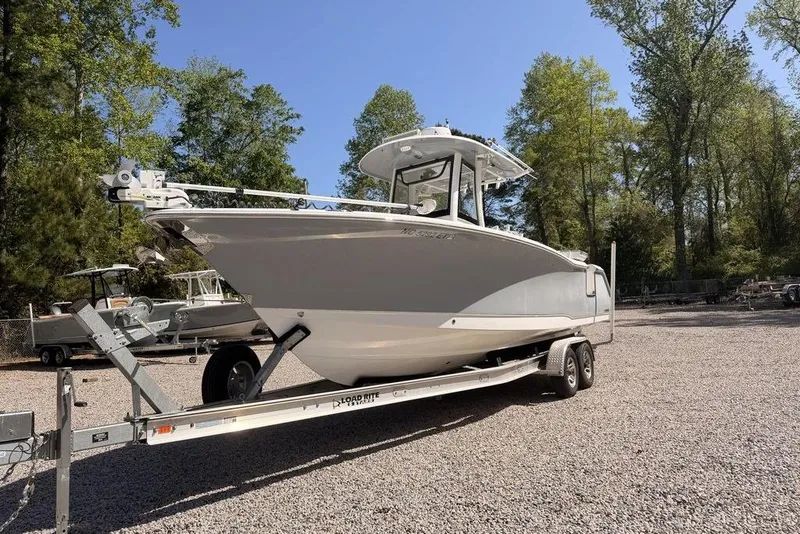 The Image of 2021 Sea Hunt Gamefish 27 boat on trailer, parked outdoors with trees in background. - 1