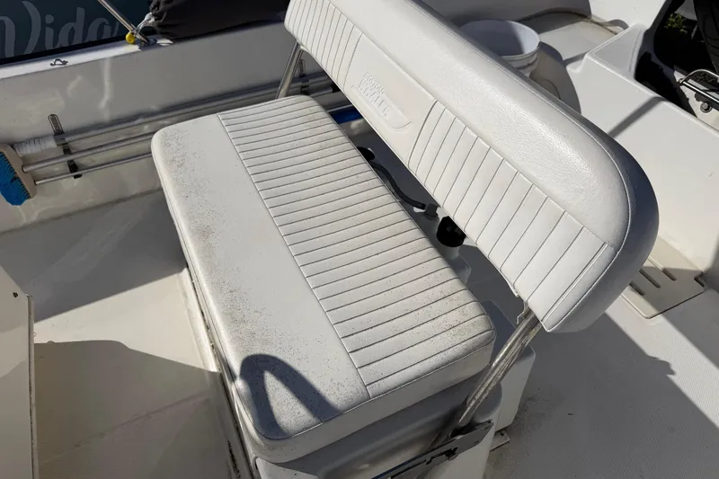 Slide: The Image of 2015 Boston Whaler 170 Montauk boat seat with white upholstery and storage underneath. - 12