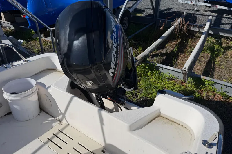 Slide: The Image of 2015 Boston Whaler 170 Montauk boat with Mercury outboard motor in a yard setting. - 14