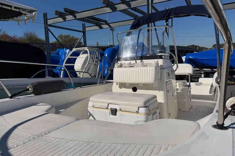 Slide: The Image of 2015 Boston Whaler 170 Montauk boat interior with seating and console, docked outdoors. - 9