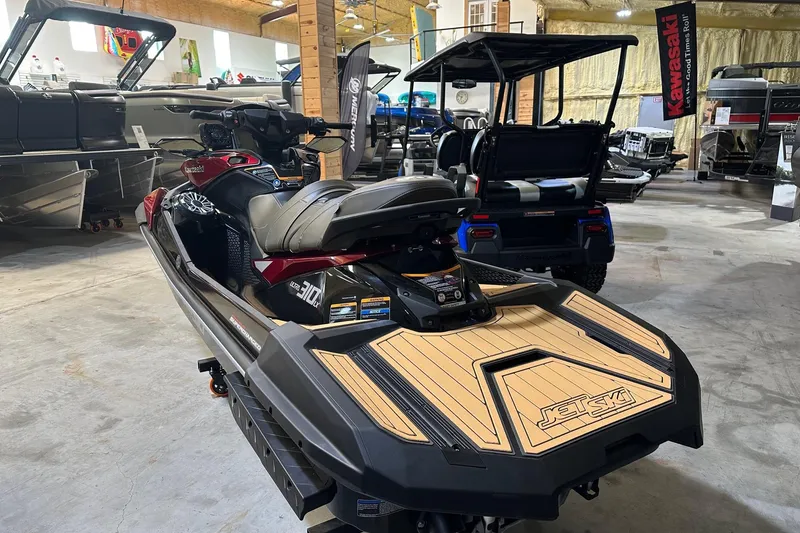 Slide: The Image of 2026 Kawasaki Jetski Ultra 310LX displayed in a showroom with other vehicles. - 2