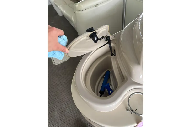 Slide: The Image of Boat storage compartment on a 2007 Crest 2570 III XRS, open with blue tool inside. - 15