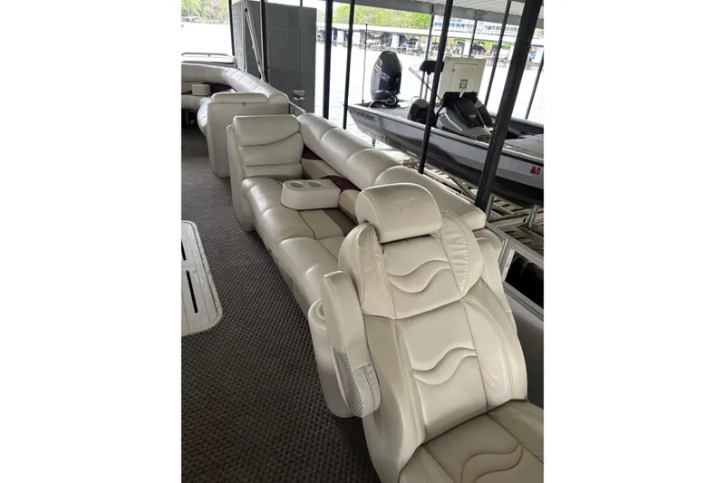 Slide: The Image of Luxurious seating on a 2007 Crest 2570 III XRS boat, docked with watercraft nearby. - 18