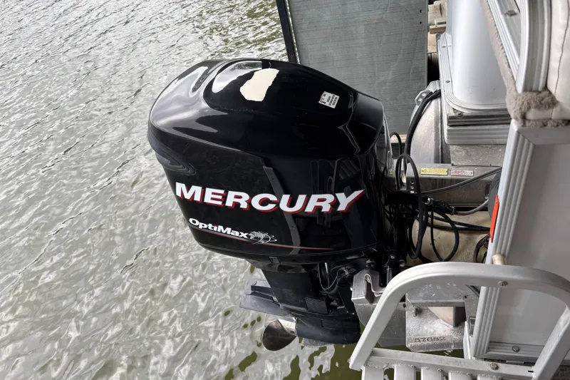 Slide: The Image of Mercury OptiMax outboard motor on 2007 Crest 2570 III XRS boat, docked on water. - 22