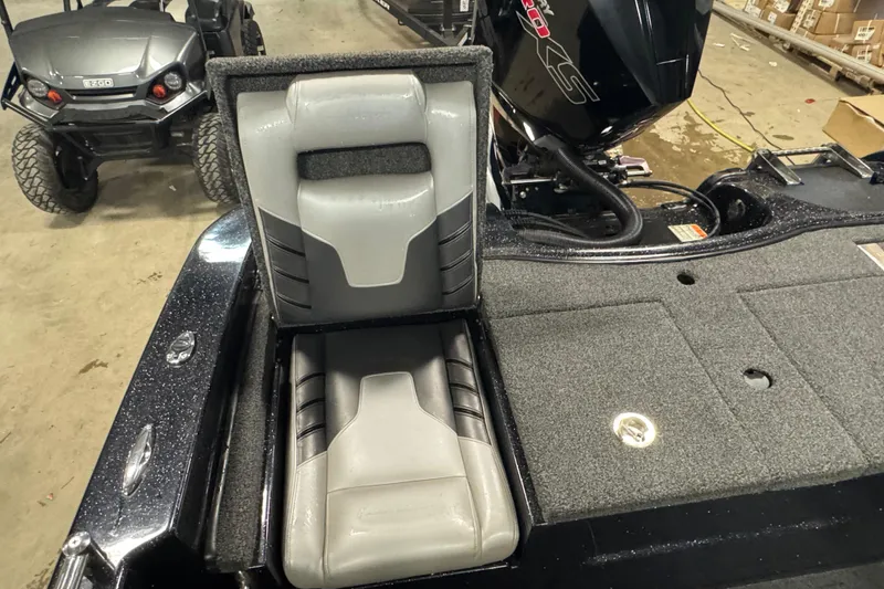 Slide: The Image of 2021 Nitro ZV19 Sport boat interior with gray seating and motor, in a garage setting. - 22