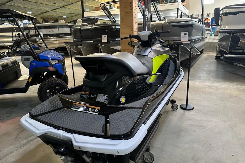 Slide: The Image of 2026 Kawasaki ST 160X jet ski displayed in a showroom with boats and vehicles. - 2