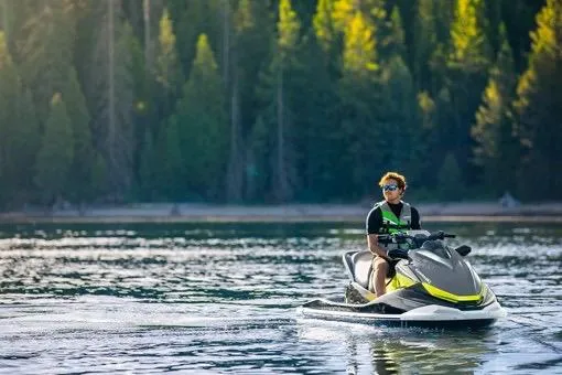 Slide: The Image of Person riding 2026 Kawasaki ST 160X jet ski on a serene lake with forest backdrop. - 5