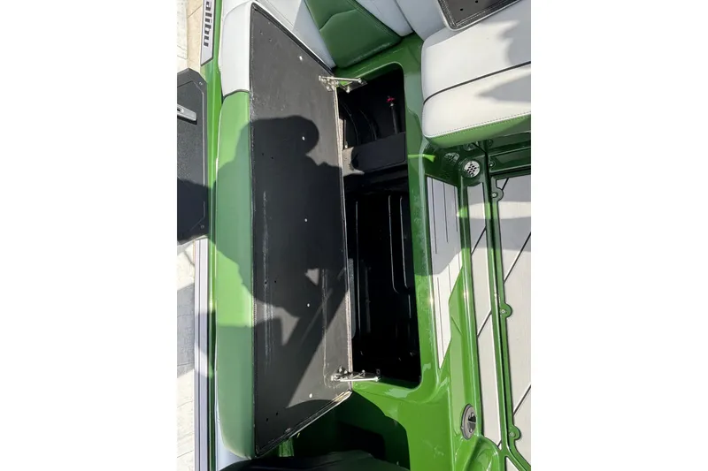 Slide: The Image of 2021 Malibu Wakesetter 21 VLX open storage compartment, green and white interior. - 12