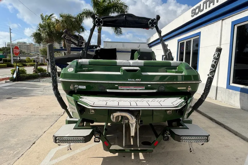 Slide: The Image of 2021 Malibu Wakesetter 21 VLX boat, green, parked outside dealership. - 3