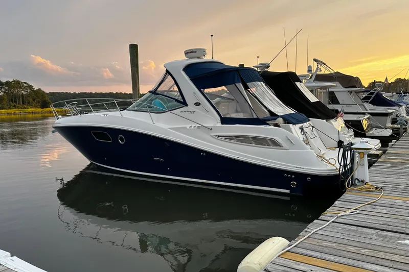 The Image of 2012 Sea Ray Sundancer 350 yacht docked at sunset, calm waters, marina setting. - 1