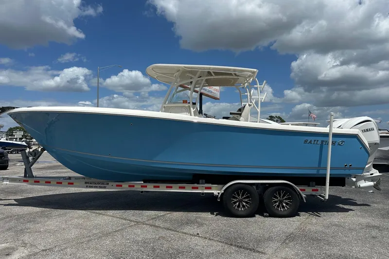 The Image of 2022 Sailfish 290 CC boat on trailer under blue sky. - 0