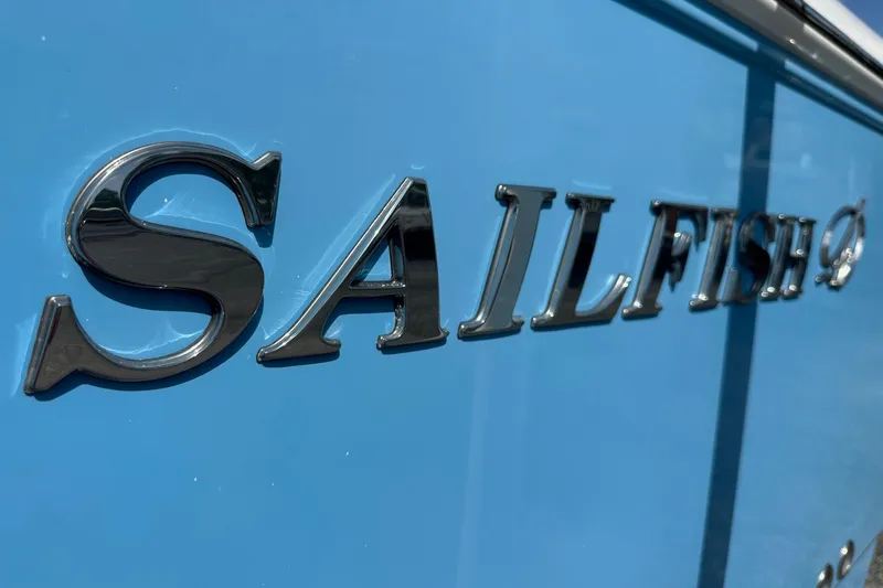 Slide: The Image of Close-up of 2022 Sailfish 290 CC logo on a blue boat exterior. - 10