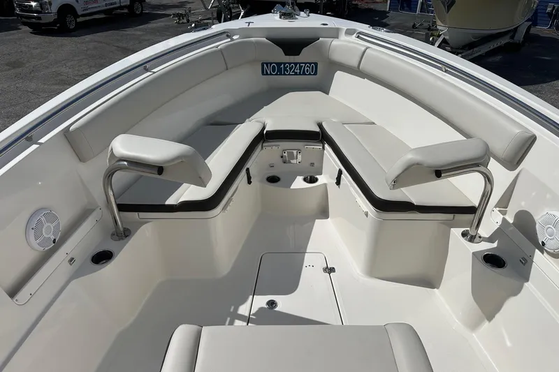 Slide: The Image of 2022 Sailfish 290 CC boat interior with cushioned seating and cup holders. - 12